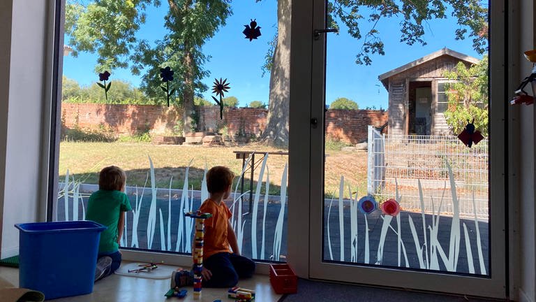 Kinder schauen vom Kinderhaus nach draußen (Foto: Herzenssache)