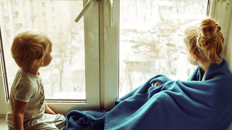 Kinder sitzen auf einer Fensterbank (Foto: Unsplash / Vitolda Klein)