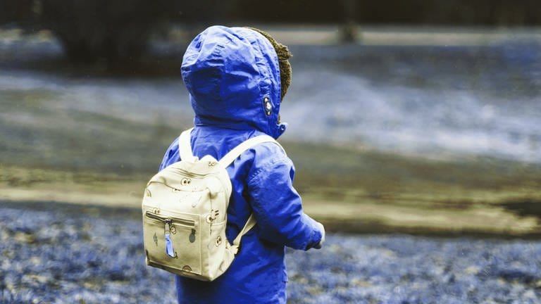 Kind mit Rucksack und Regenjacke (Foto: Unsplash / Daiga Ellaby)