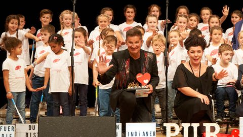 Hartmut Engler mit Herzenssache-Kids auf der Bühne (Foto: Seventyfour.studio)