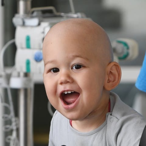 Krebskranker Junge lacht in die Kamera