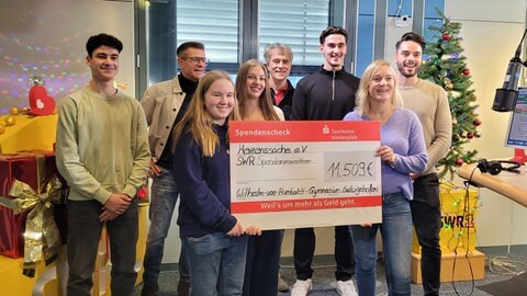 Schülerinnen und Schüler übergeben einen Spendenscheck an Herzenssache (Foto: Herzenssache) Schülerinnen und Schüler übergeben einen Spendenscheck an Herzenssache