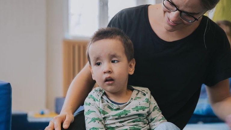Junge sitzt in Therapieraum
