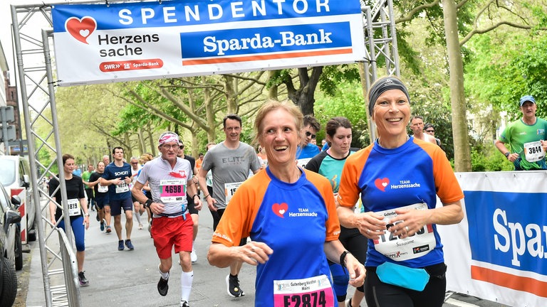 Läuferinnen laufen durch das Spendentor (Foto: Peter Pulkowski)