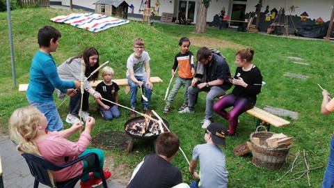 Kinder im Sommercamp Andernach backen Stockbrot (Foto: Herzenssache)