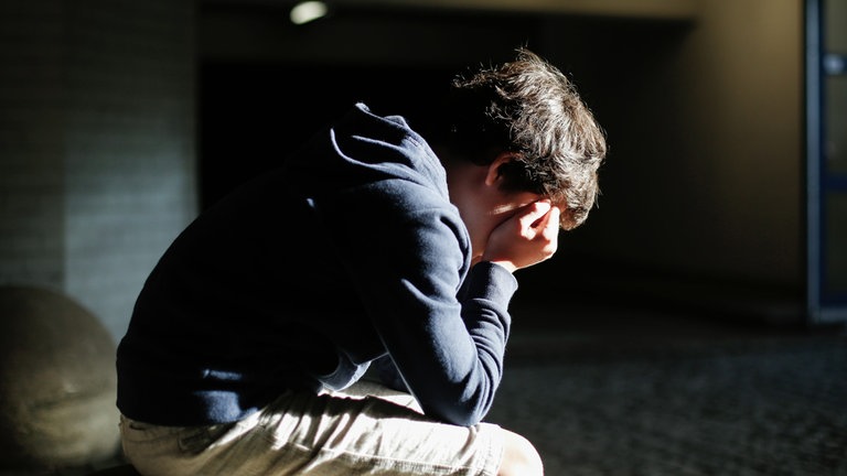 Junge sitzt gebeugt auf einem Stein (Foto: DKSB/Susanne Tessa Müller)