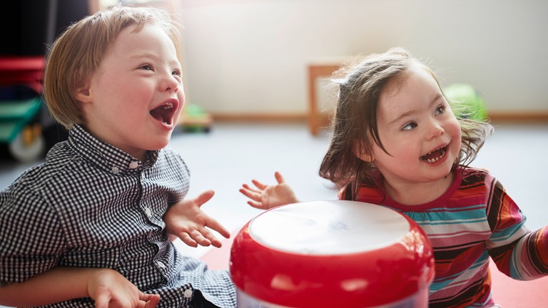 Zwei Kinder mit Down-Syndrom spielen in der Kita