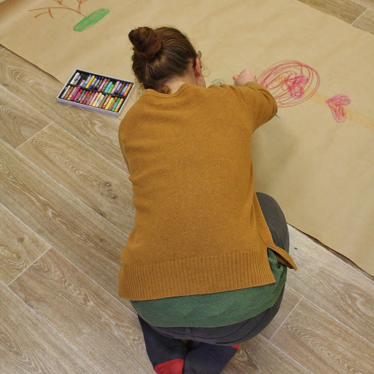 Mädchen malt auf dem Boden  (Foto: Herzenssache)