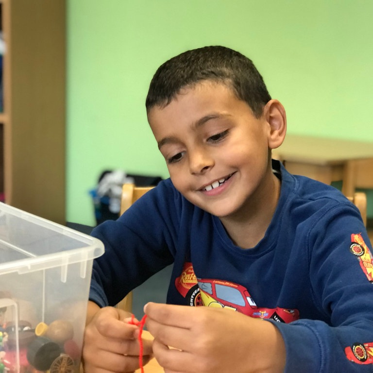 Kind bastelt in Herzenssache-Projekt der Caritas Heidelberg (Foto: Herzenssache)