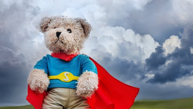 Bär mit Superhelden-Umhang vor Gewitterwolken (Foto: Getty Images, iStock)