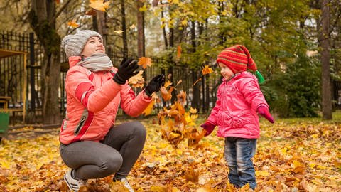 Frau spielt mit kleinem Mädchen im Herbstlaub. (Foto: Pixabay )