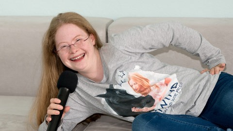 Foto: Herzenssache Rosalie mit einem Mikrophon (Foto: Herzenssache)