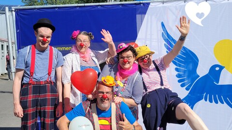 Die Clowns von true!moments vor einer Wand mit ukrainischer Friedenstaube (Foto: true!moments)