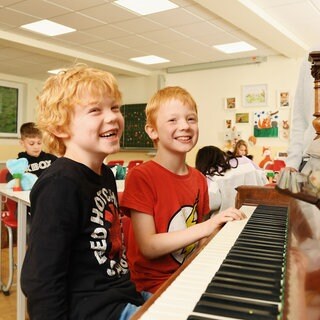 Lachende Jungen am Klavier (Foto: Carsten Costard)