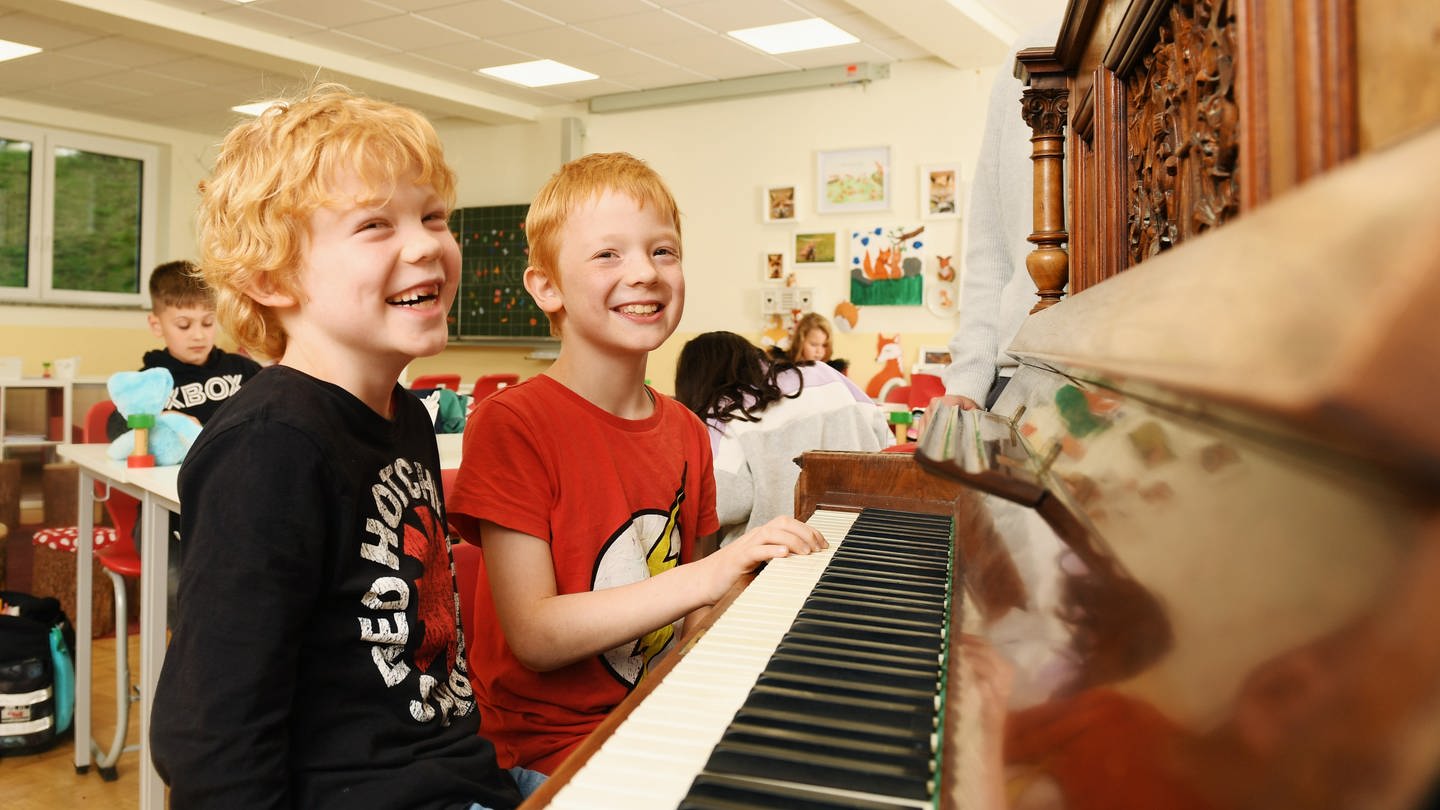Lachende Jungen am Klavier (Foto: Carsten Costard)