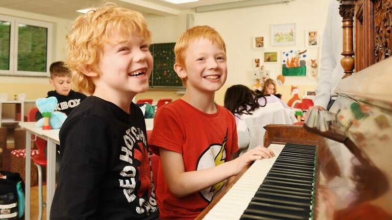 Lachende Jungen am Klavier (Foto: Carsten Costard)