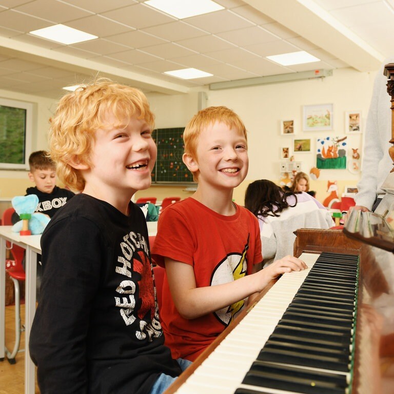 Lachende Jungen am Klavier (Foto: Carsten Costard)