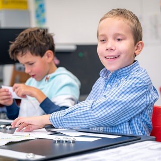 Blinder Junge sitzt an einem Tisch (Foto: Marcel Katz)
