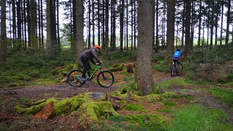Zwei Radfahrer im Wald (Foto: Herzenssache e.V.) Zwei Radfahrer im Wald