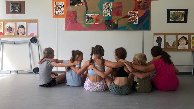 Kinder haben die Arme verschränkt und bilden eine Kette (Foto: Herzenssache e.V.)