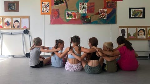 Kinder haben die Arme verschränkt und bilden eine Kette (Foto: Herzenssache e.V.)