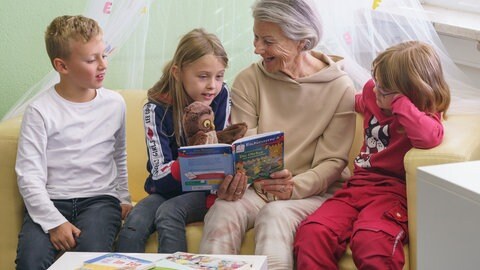 Lesepatin sitzt mit drei Kindern auf einem Sofa (Foto: Ingrid Vielsack)