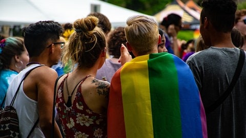 Jugenldiche mit Regenbogenfahne (Foto: Pexels / Brett Sayles)