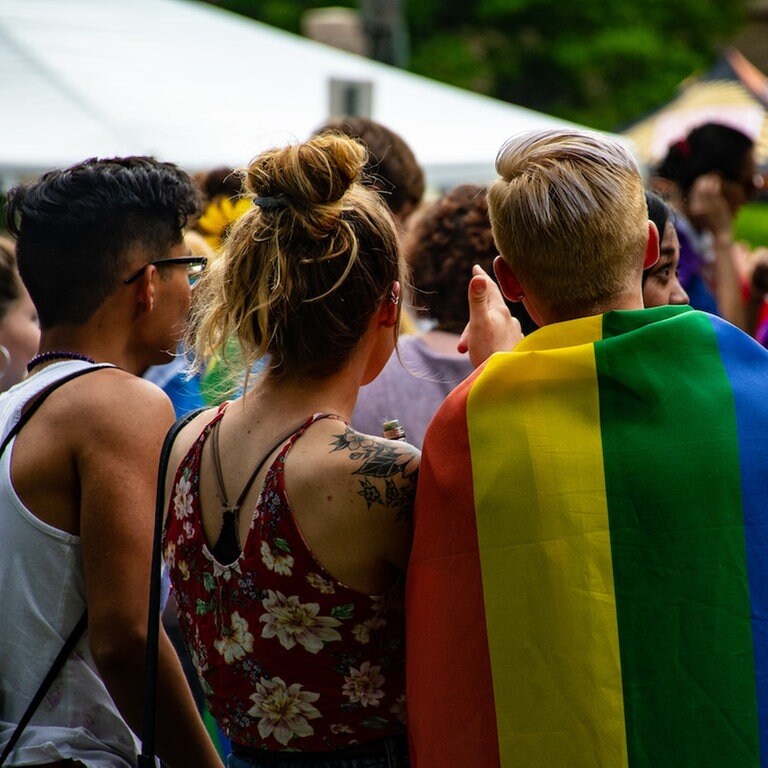 Jugenldiche mit Regenbogenfahne (Foto: Pexels / Brett Sayles)