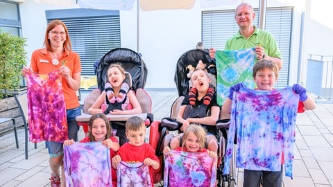 Kinder halten gebatikte T-Shirts hoch (Foto: Marcel Katz)