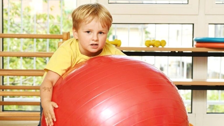 Junge umklammert Gymnastikball (Foto: Carsten Costard)