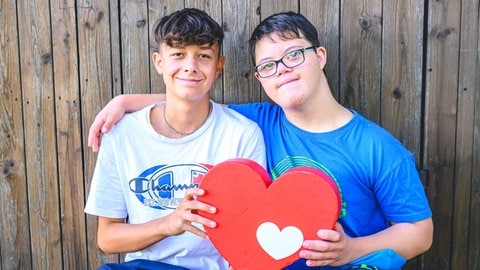 Lukas (links) und Mattheo (recht, Junge mit Down Snydrom) halten das Herzenssache-Herz (Foto: Marcel Katz) Lukas (links) und Mattheo (recht, Junge mit Down Snydrom) halten das Herzenssache-Herz