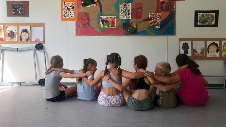 Kinder haben die Arme verschränkt und bilden eine Kette (Foto: Herzenssache e.V.) Kinder haben die Arme verschränkt und bilden eine Kette