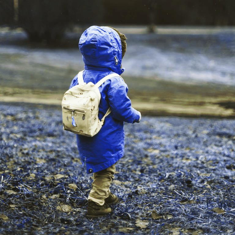 Kind mit Rucksack und Regenjacke (Foto: Unsplash / Daiga Ellaby)