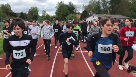 Kinder mit Nummerierung laufen auf einem Sportplatz (Foto: Andreas Elbe)