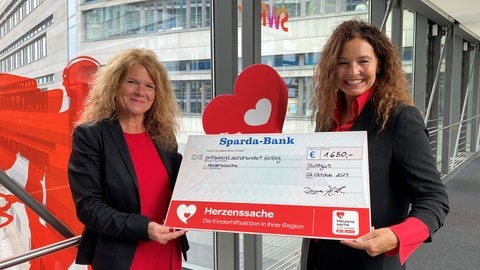 Künstlerin Dagmar Härle überreicht einen Scheck an Herzenssache. (Foto: Herzenssache) Künstlerin Dagmar Härle überreicht einen Scheck an Herzenssache.