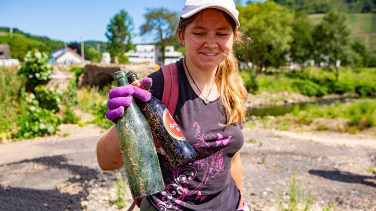 Jugendliche mit sandigen Flaschen - Clean Up-Event 3.7.22 (Foto: Clean River Project / Stephan Horch) Jugendliche mit sandigen Flaschen - Clean Up-Event 3.7.22